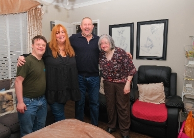 Shared Lives Carers A picture of people stood together smiling at home